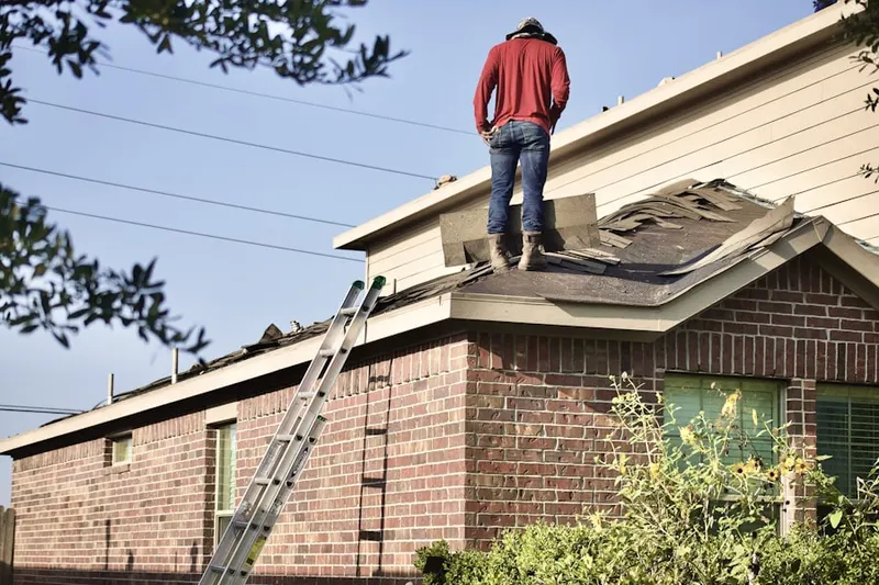 Professional roofer working on a residential roof in Rileyville